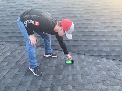 Roofer inspecting a bad shingle installation