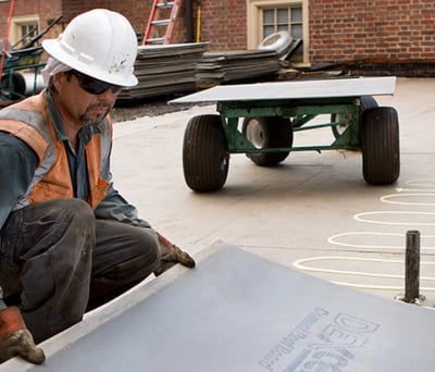 roofer installing insulation on a flat roof