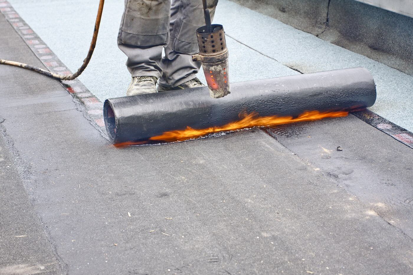 Hot rolling commercial flat roof with torch
