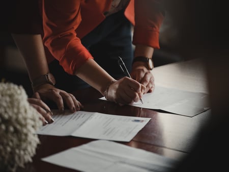 two people signing legal paperwork