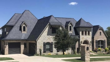 large beautiful brick home with slate f wave shingle roof