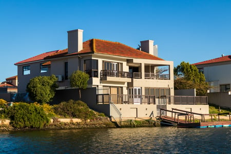 Spanish style home on the water with a tile roof