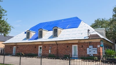 Tarp over a brick building after a severe wind storm