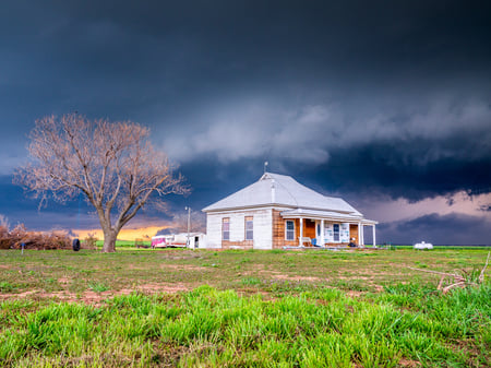 thunderstorm behind farmhouse