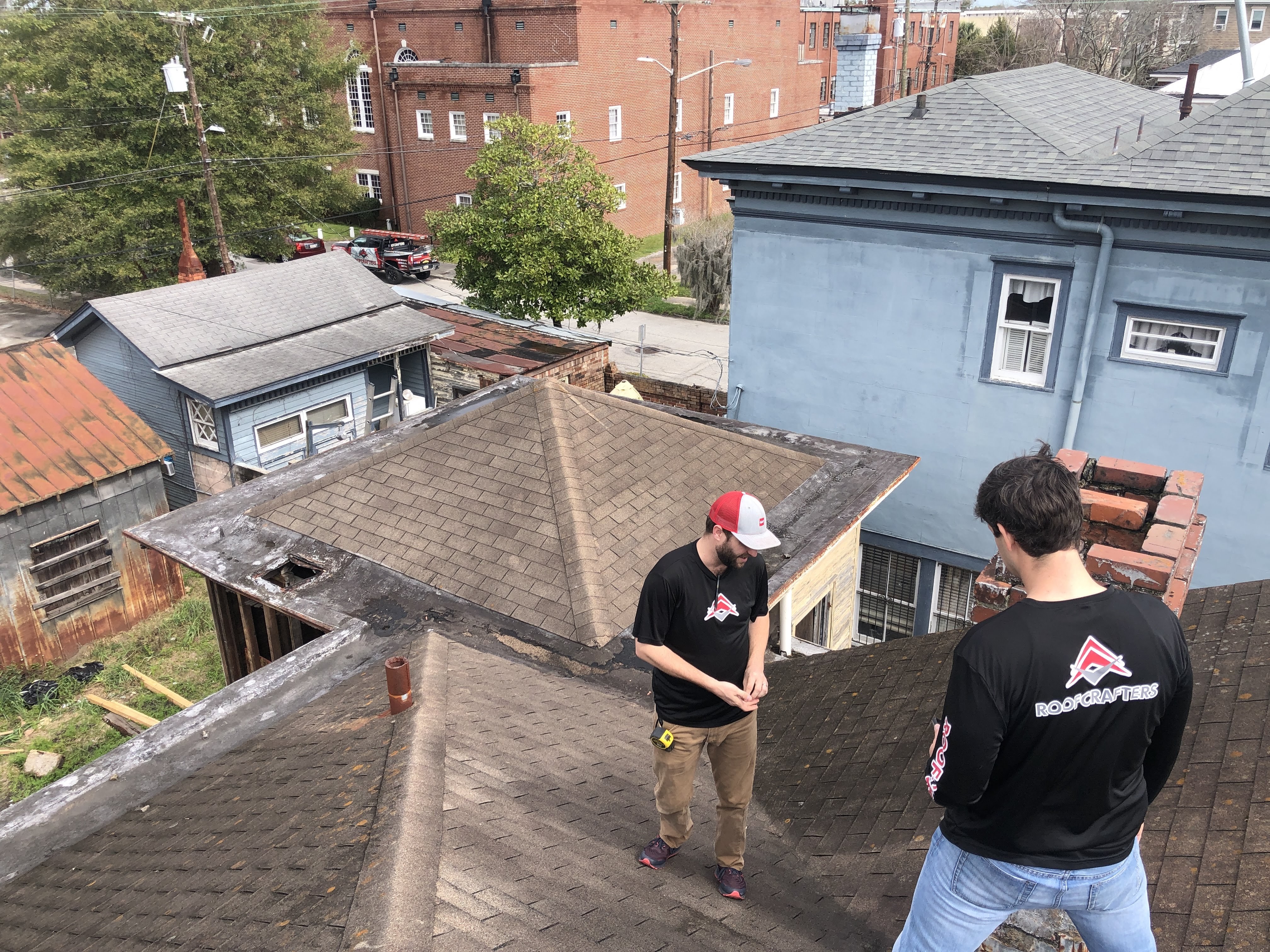 two roofers performing a roof evaluation 