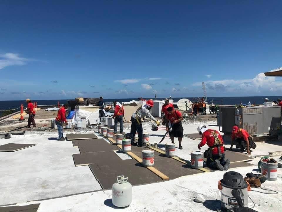 Commercial roofing crew working on a flat roof on the beach