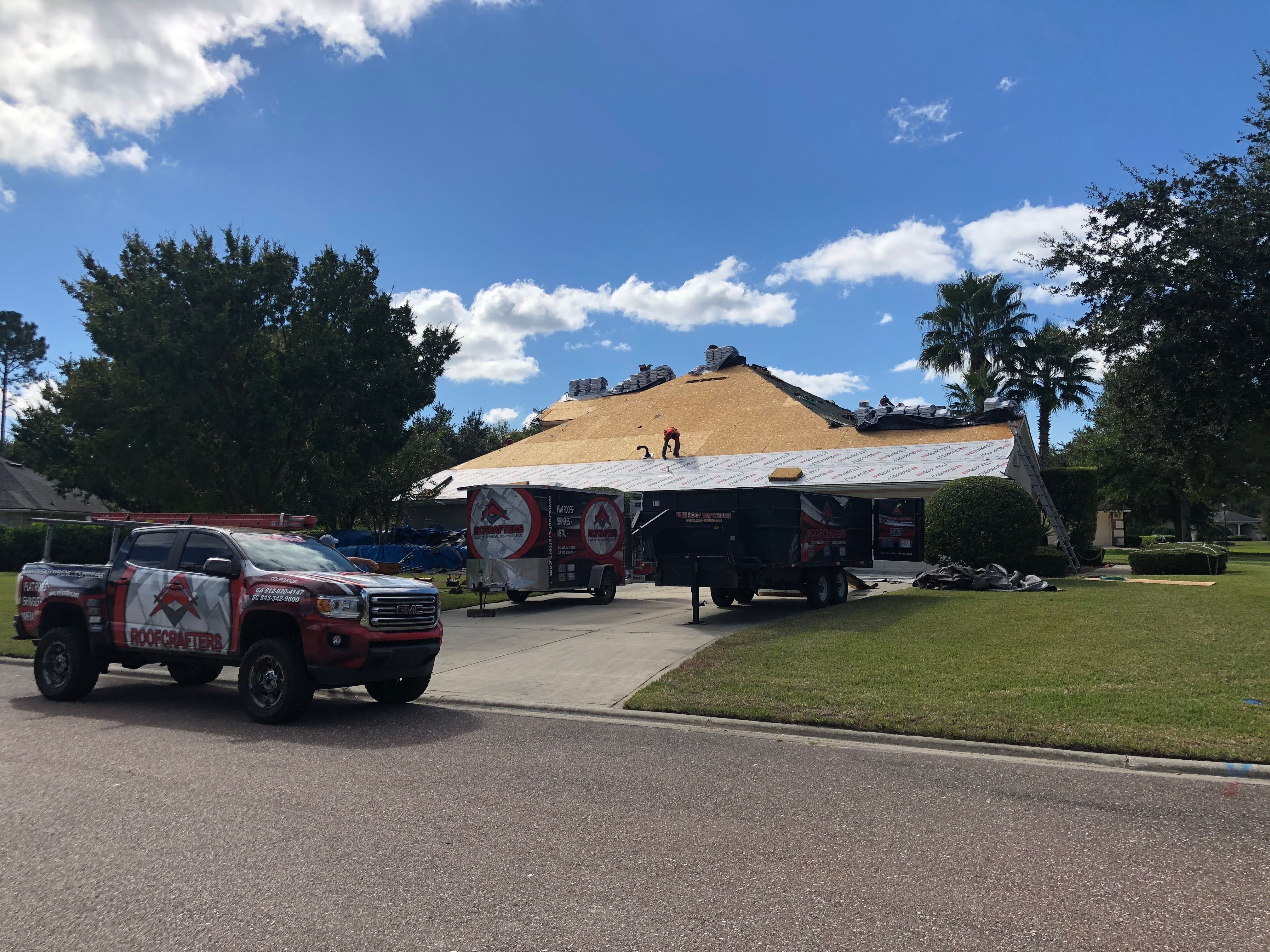 RoofCrafters truck parked in front of a home in New Smyrna Beach, a roof replacement in progress 