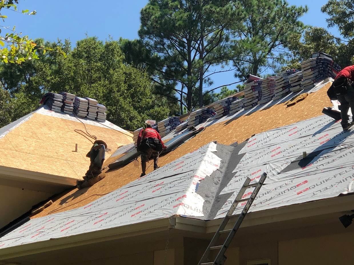 crew tearing off a roof and installing underlayment