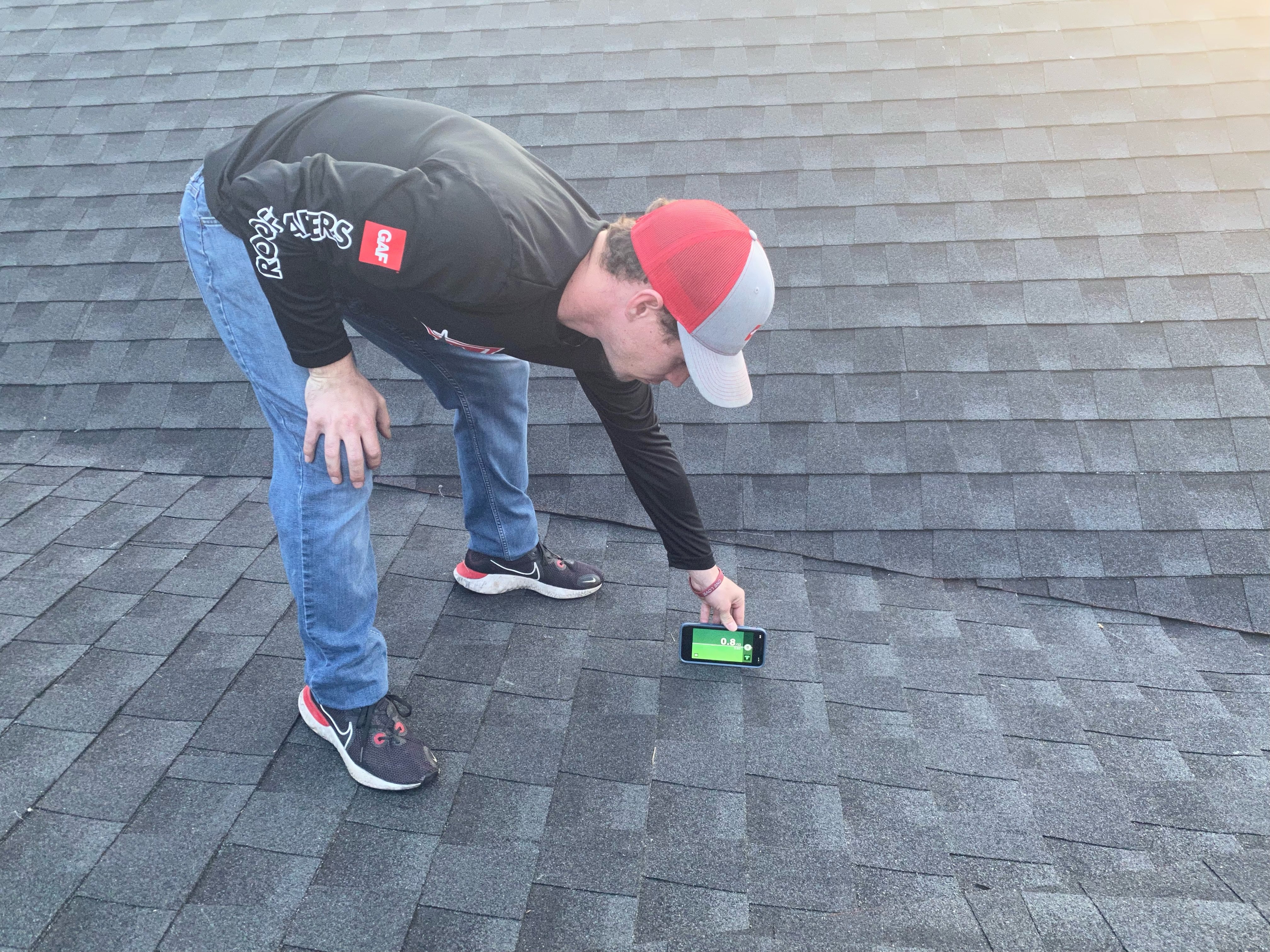 Roofing estimator inspecting an asphalt shingle roof