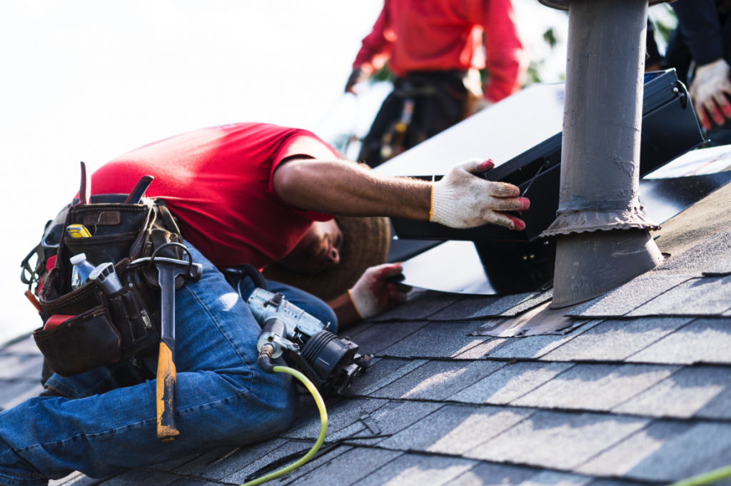 roofers performing a roof repair around an exhaust vent