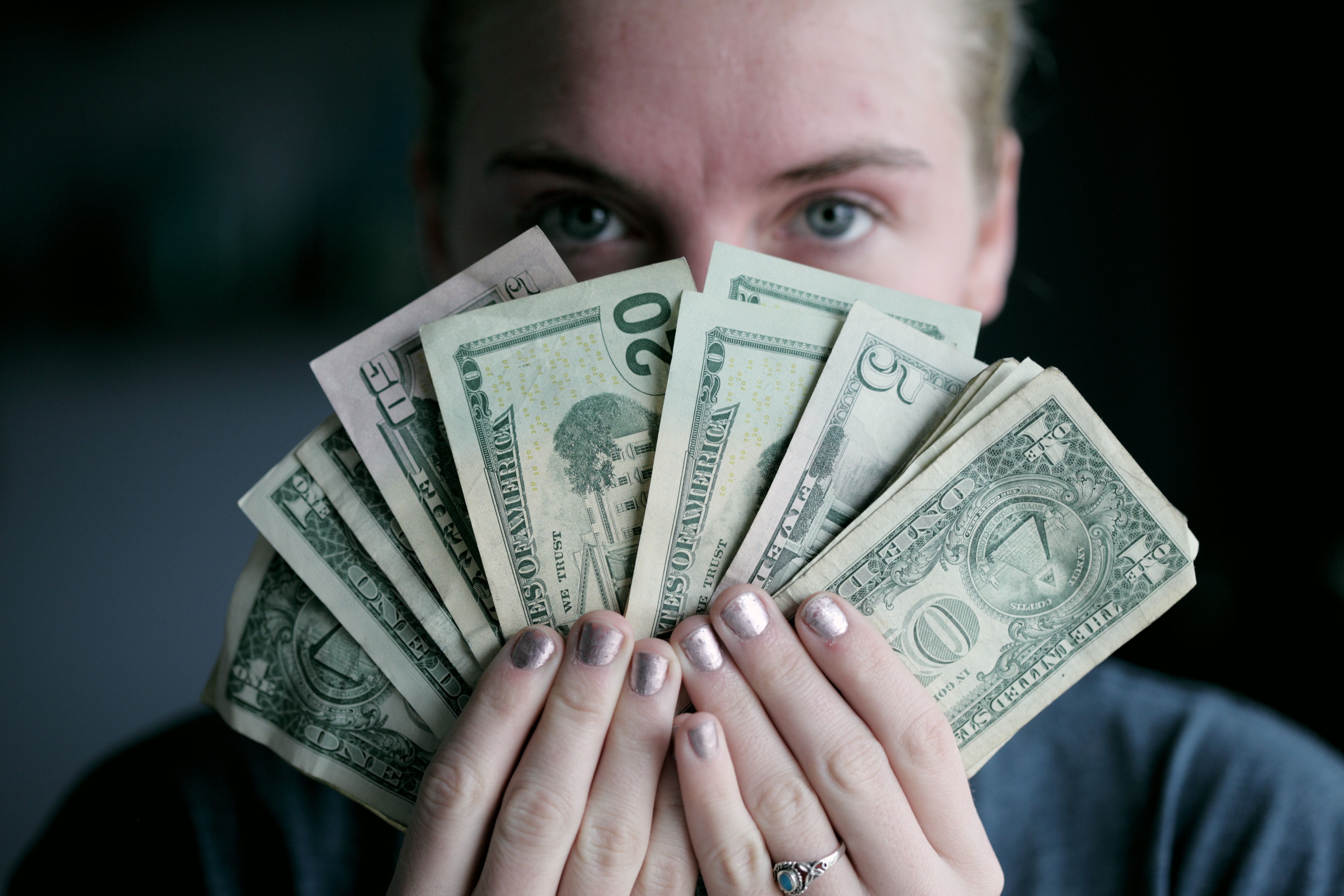 Man with same as cash in front of his face