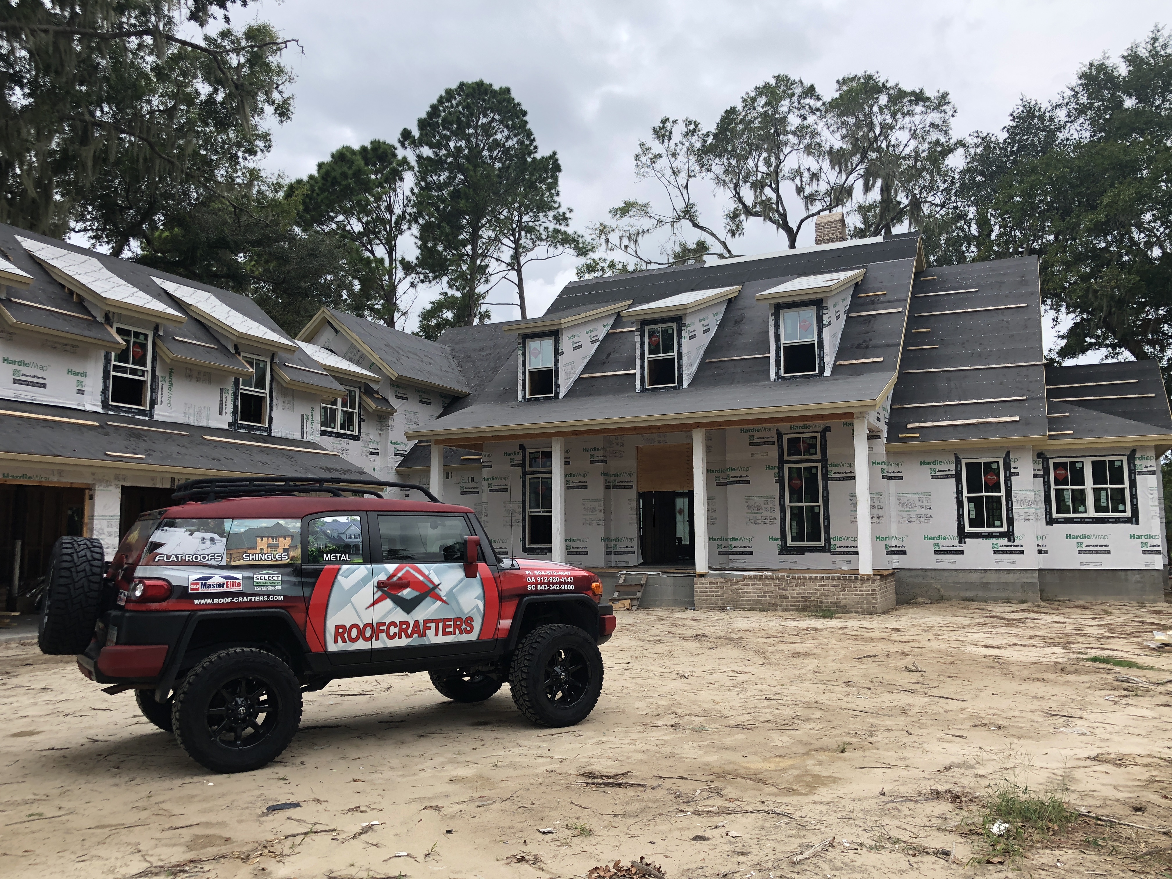RoofCrafters truck in front of a new construction home