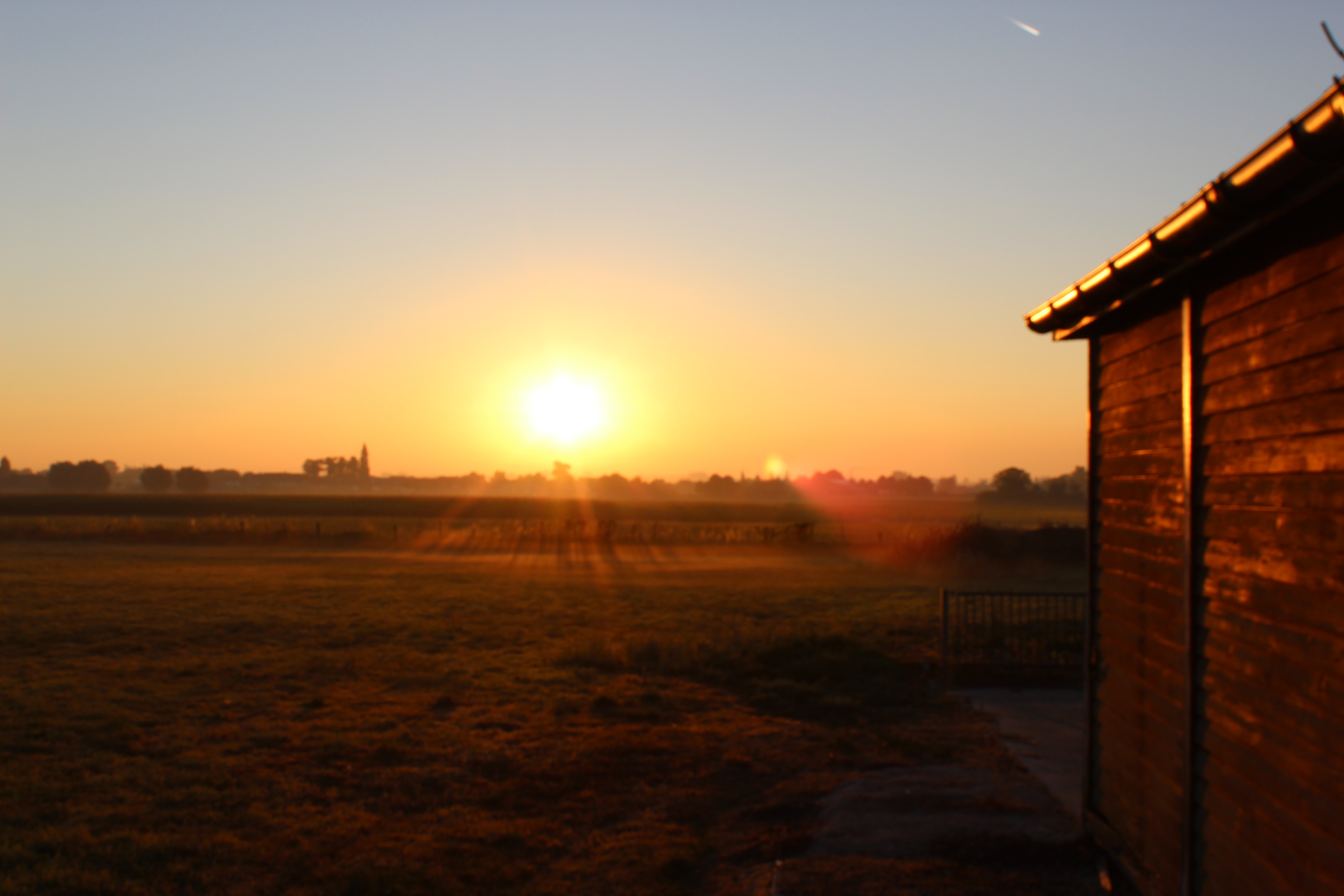 Sunrise with a side view of a home with half-round gutters