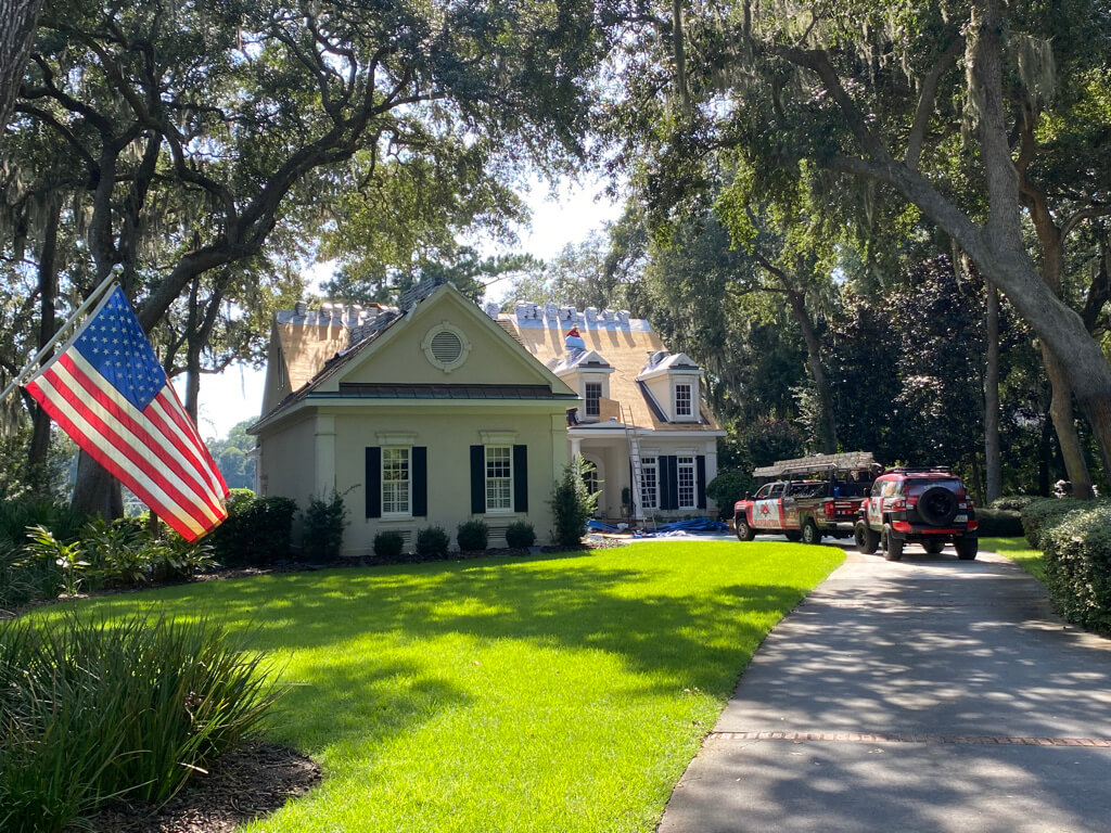 USA flag in front of home undergoing roof replacement