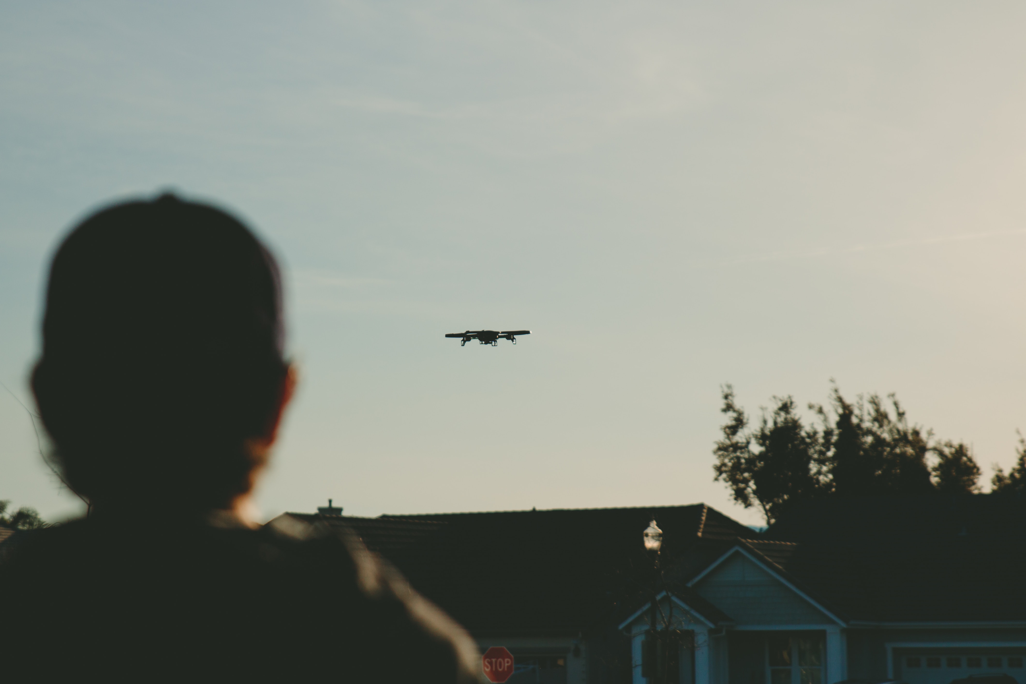 man flying drone over home