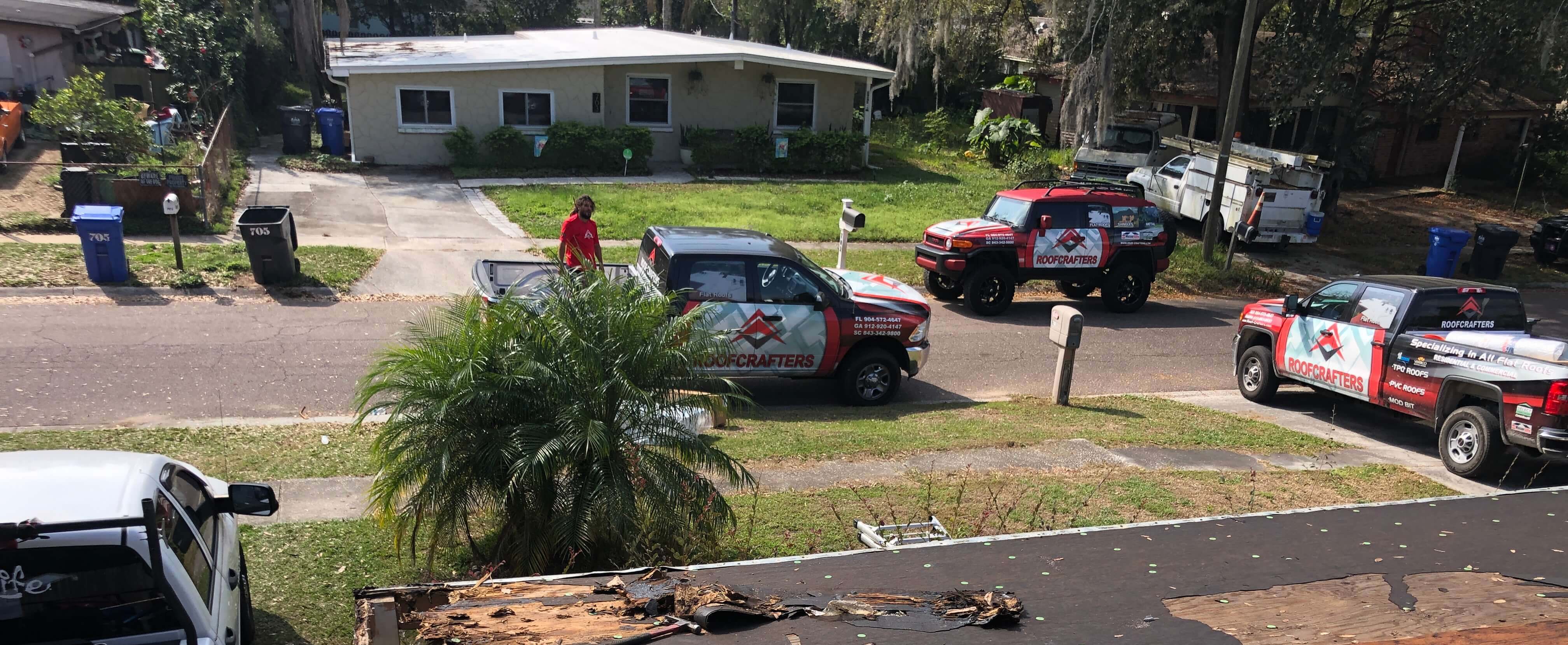 RoofCrafters trucks in front of project site