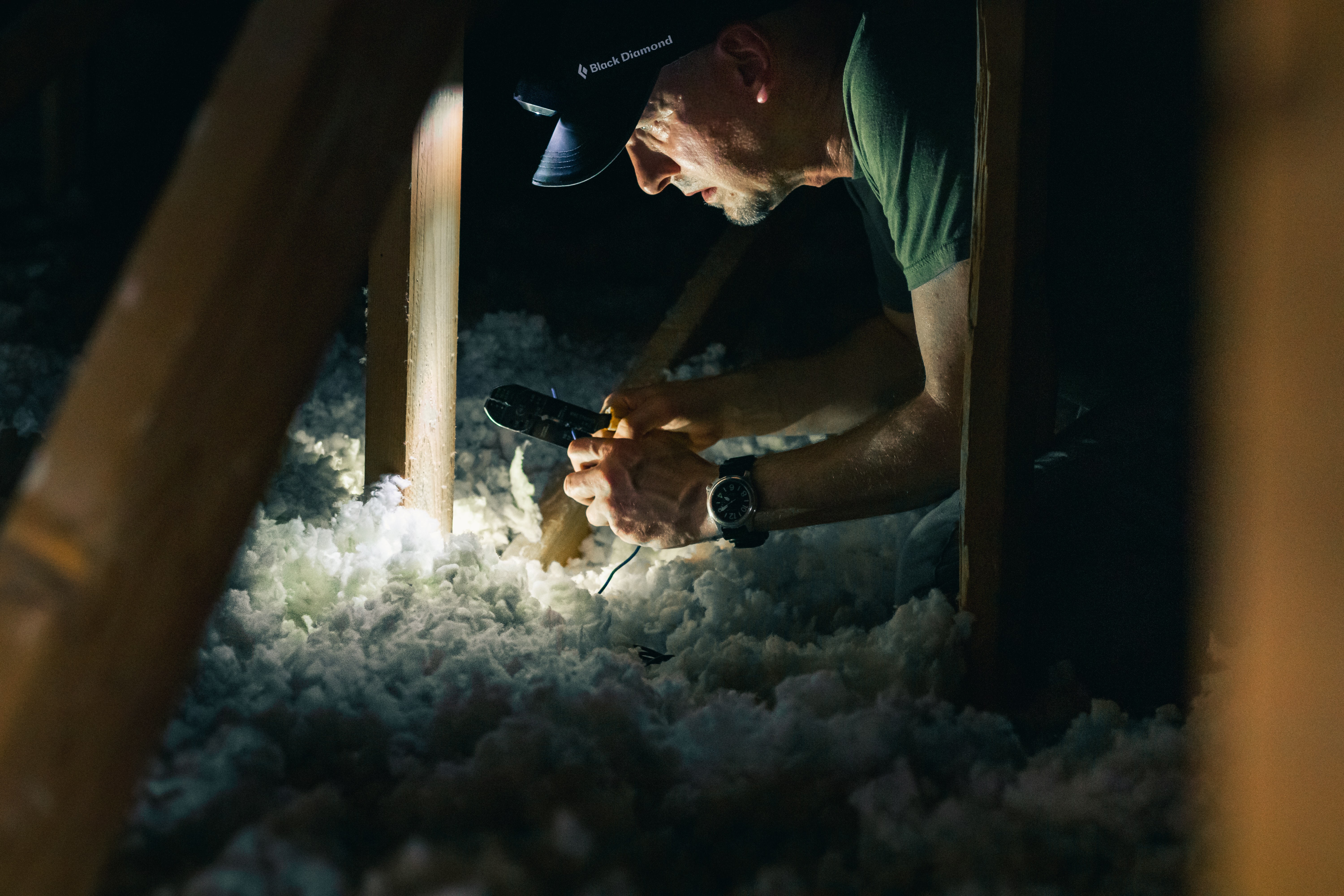 man installing insulation in attic