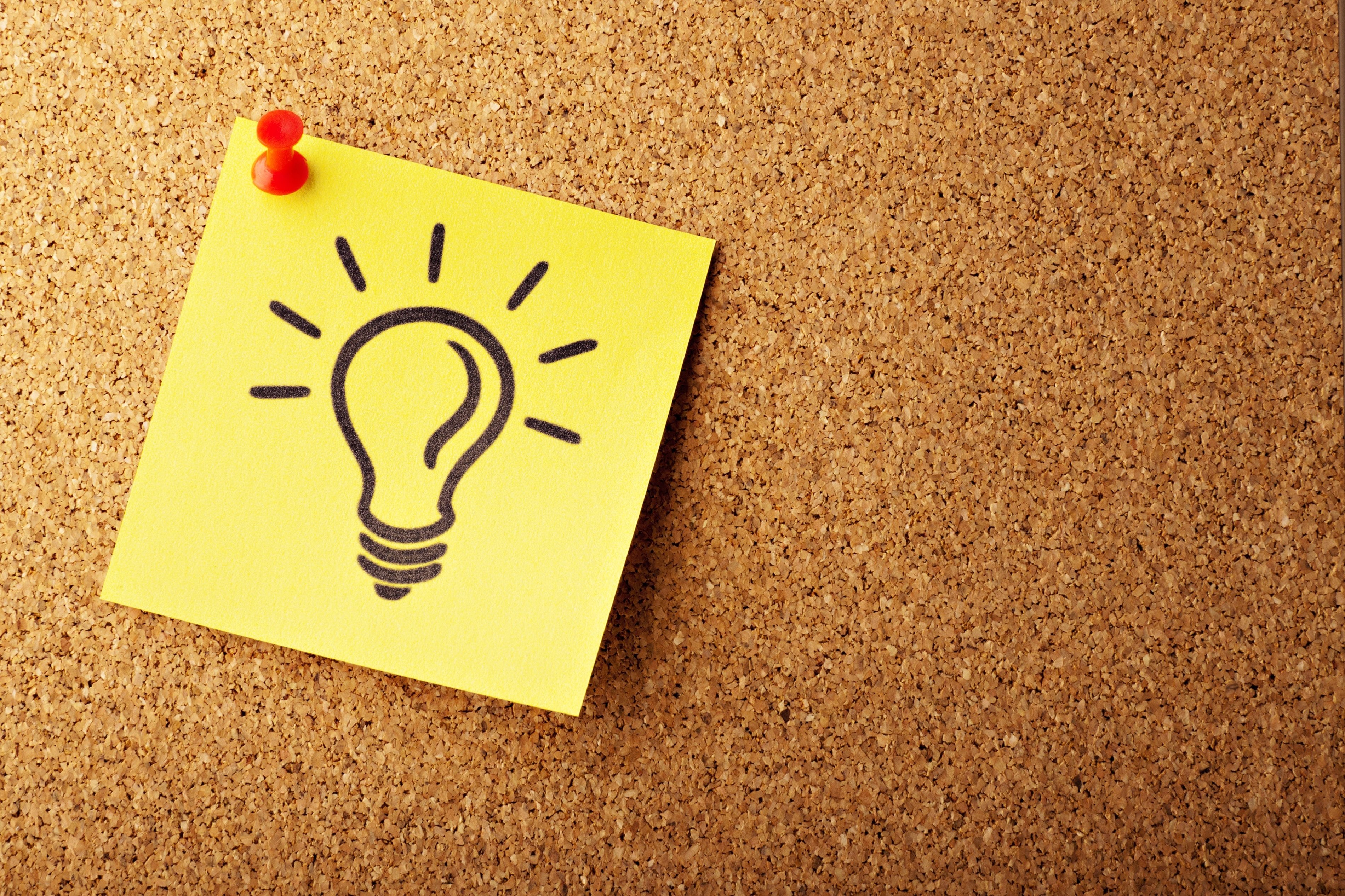 lightbulb on a post-it note depicting insightful questions pinned to a cork board