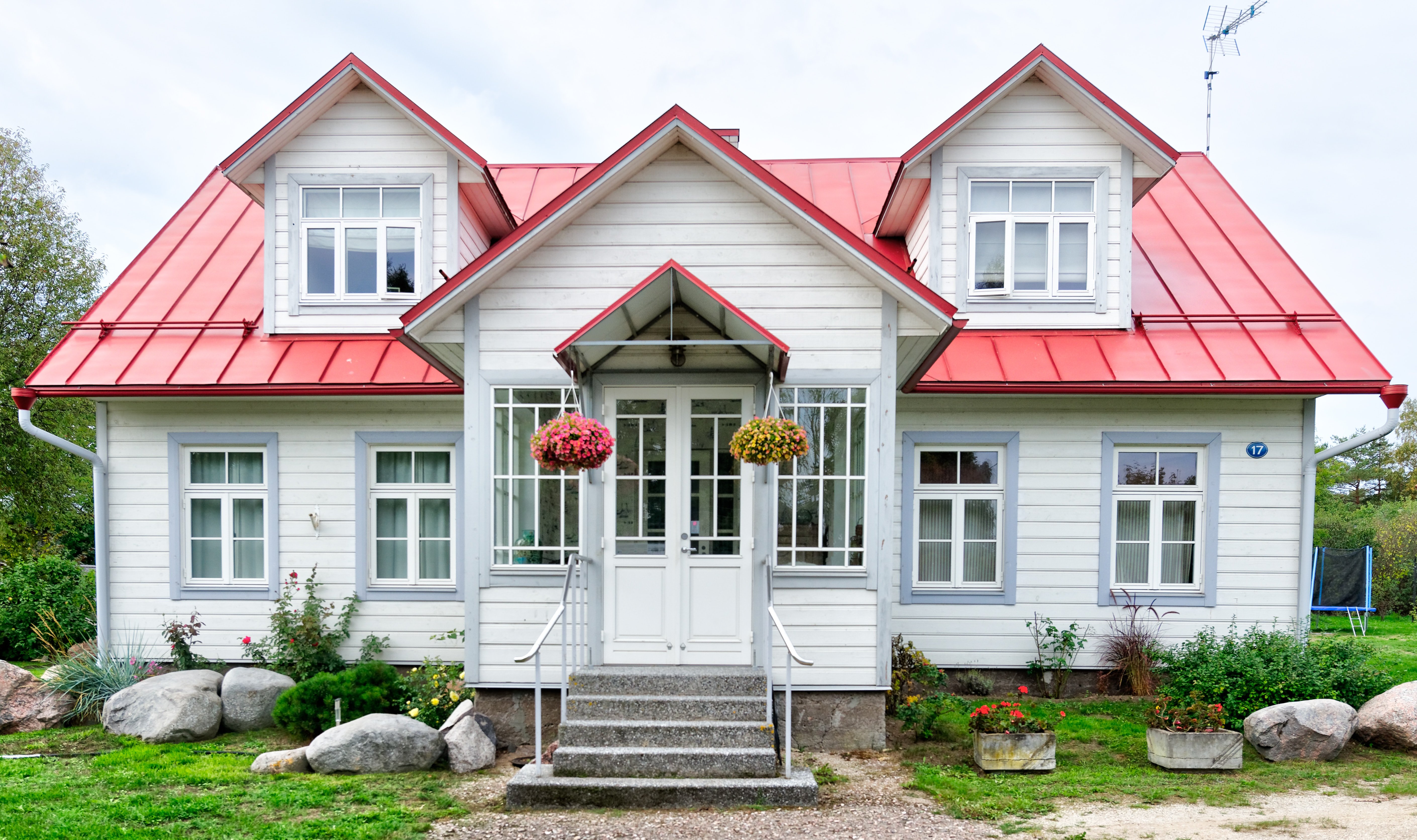 cute white home with red standing seam metal roofing