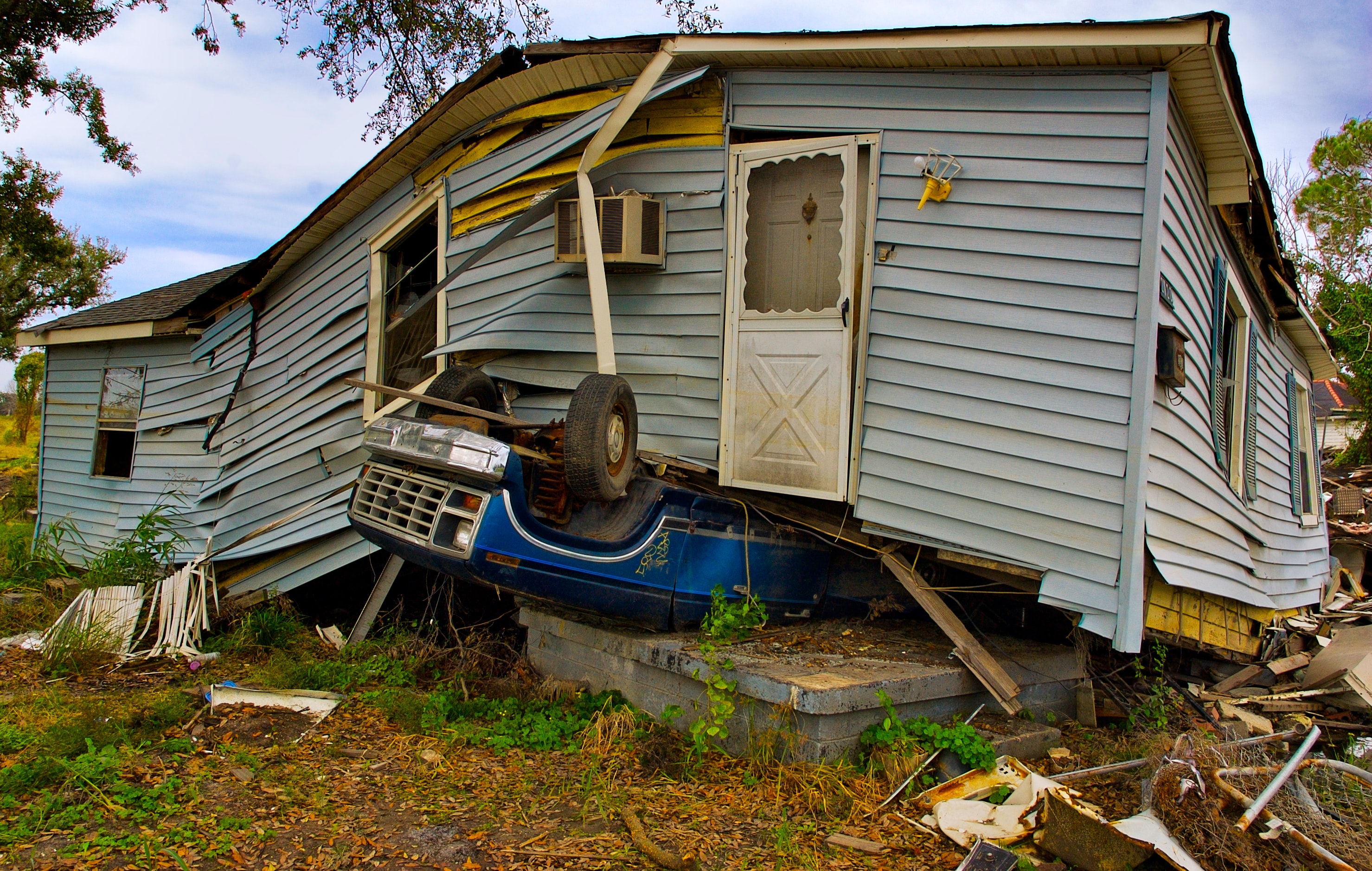 damaged home and car from hurricane