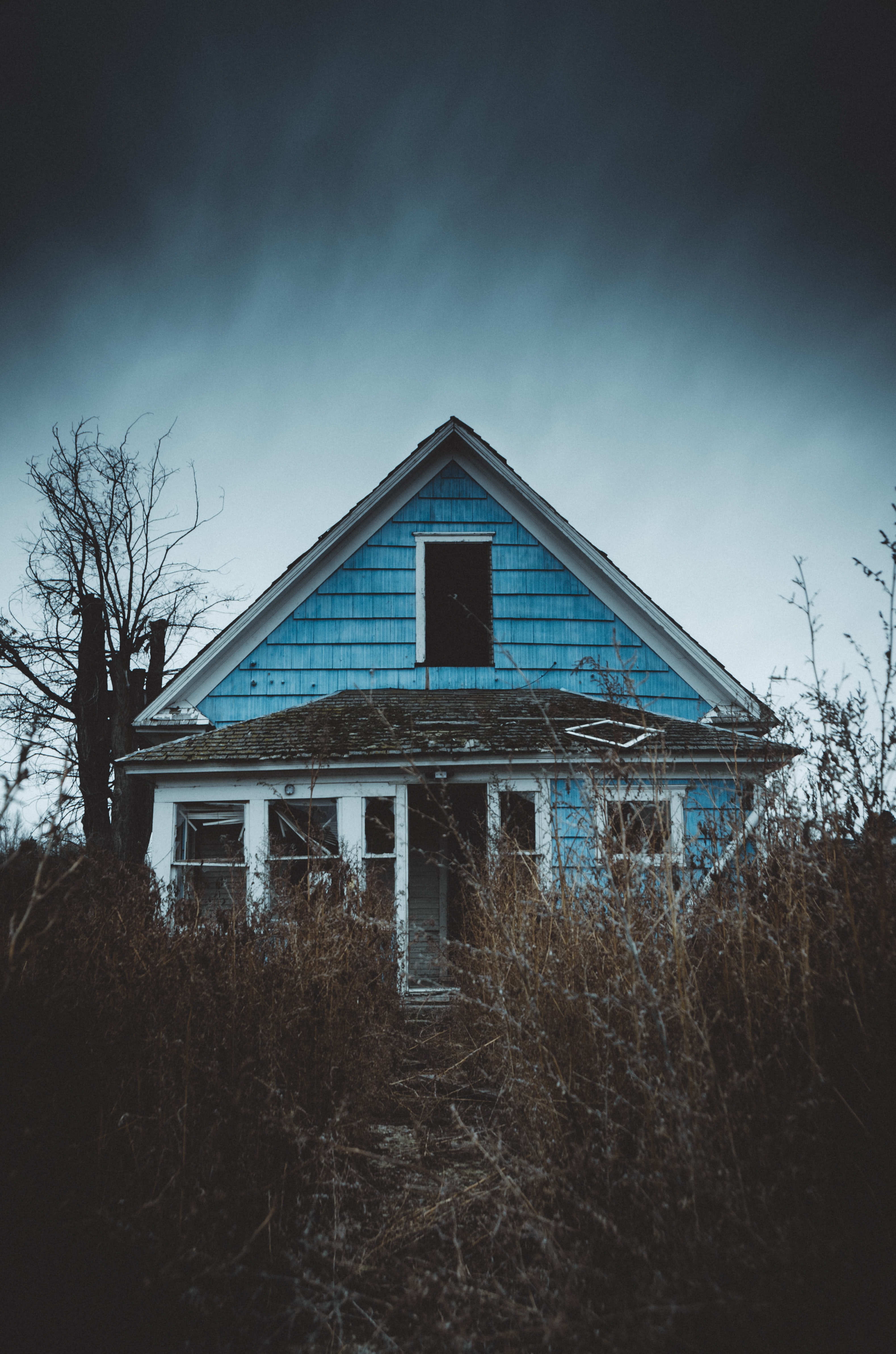 blue and white wooden house with damage