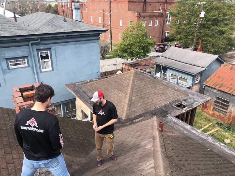 two roofers inspecting a shingle roof in Savannah Georgia