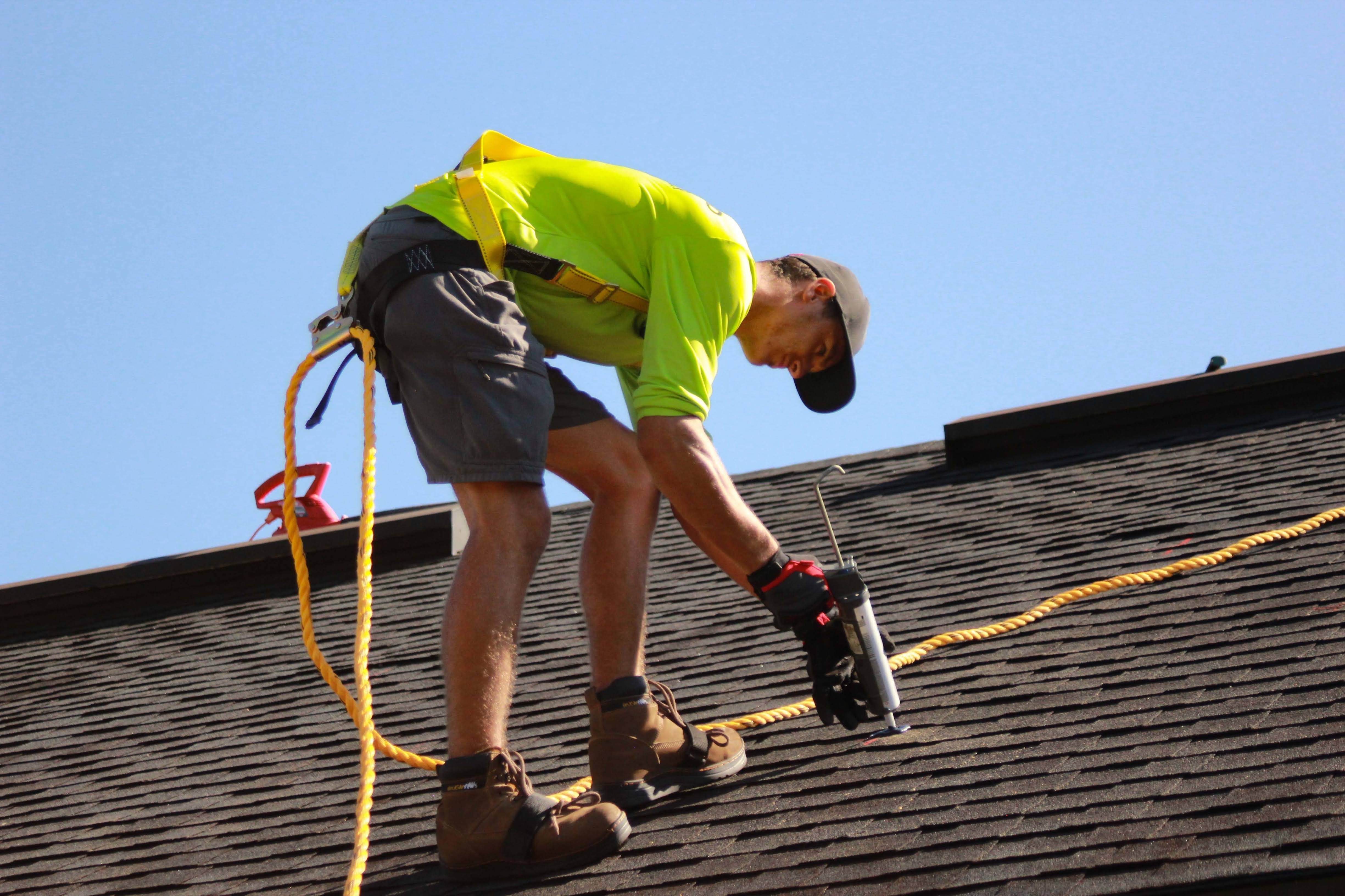 roofer wearing safety gear performing a repair