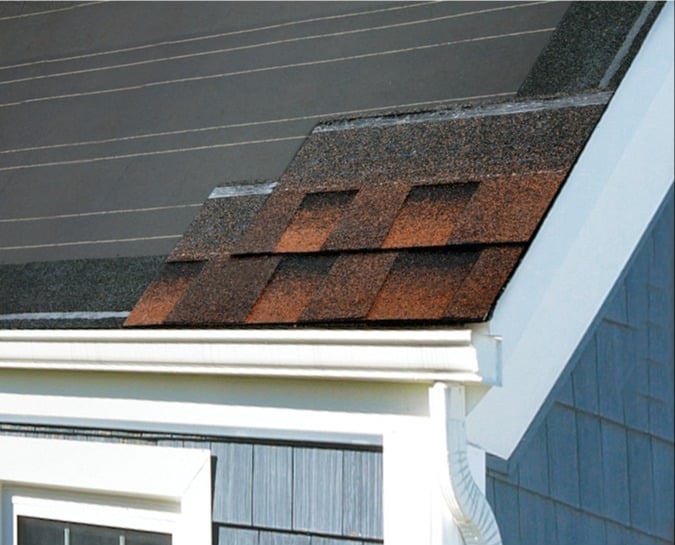 Hickory-colored architectural asphalt shingles on a rake and gutter edge corner