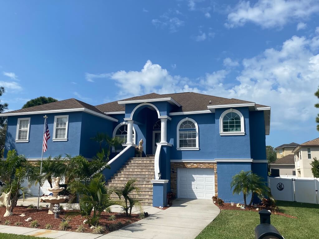 stucco home with brick roof