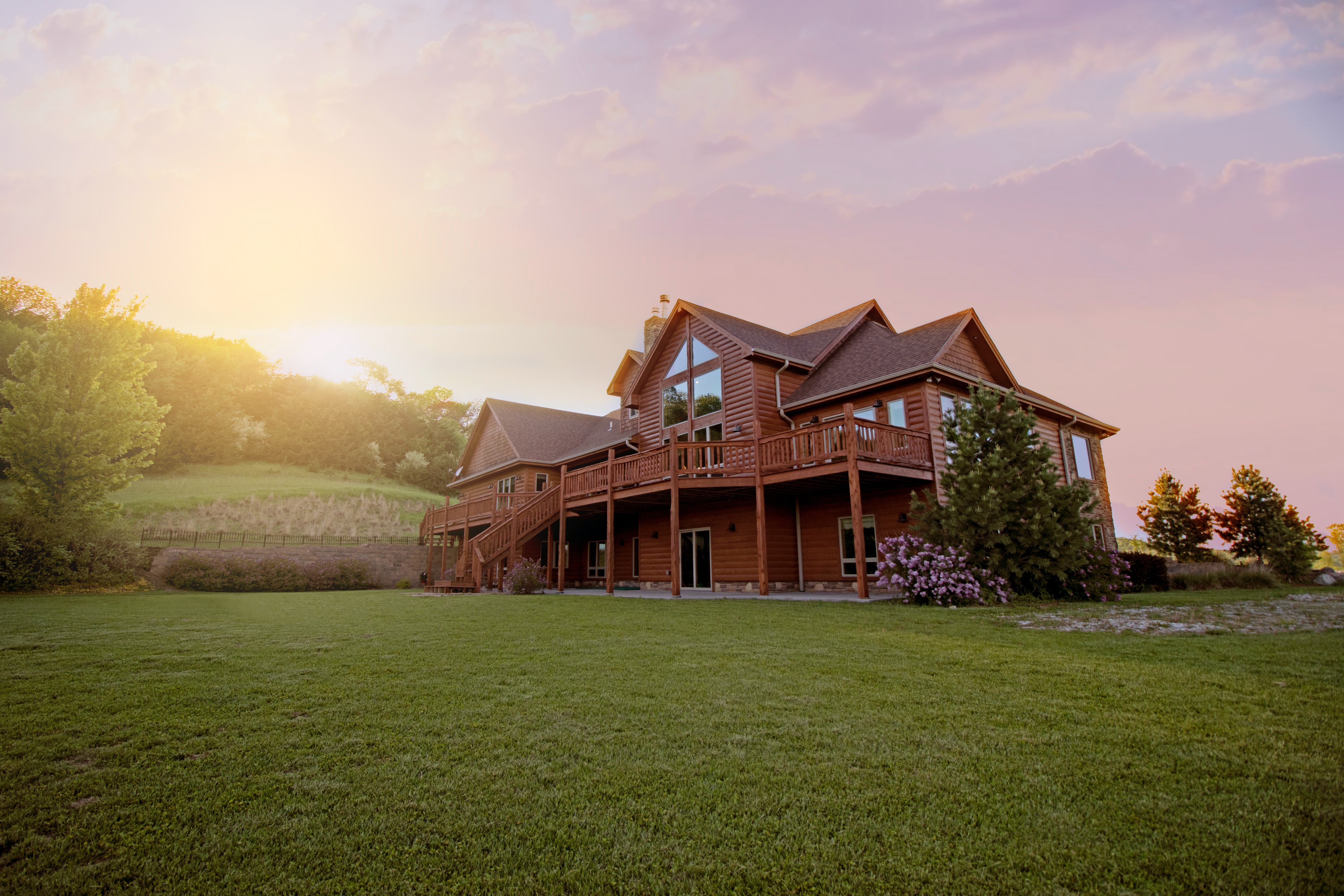 large 2 story home with a sunrise in the background