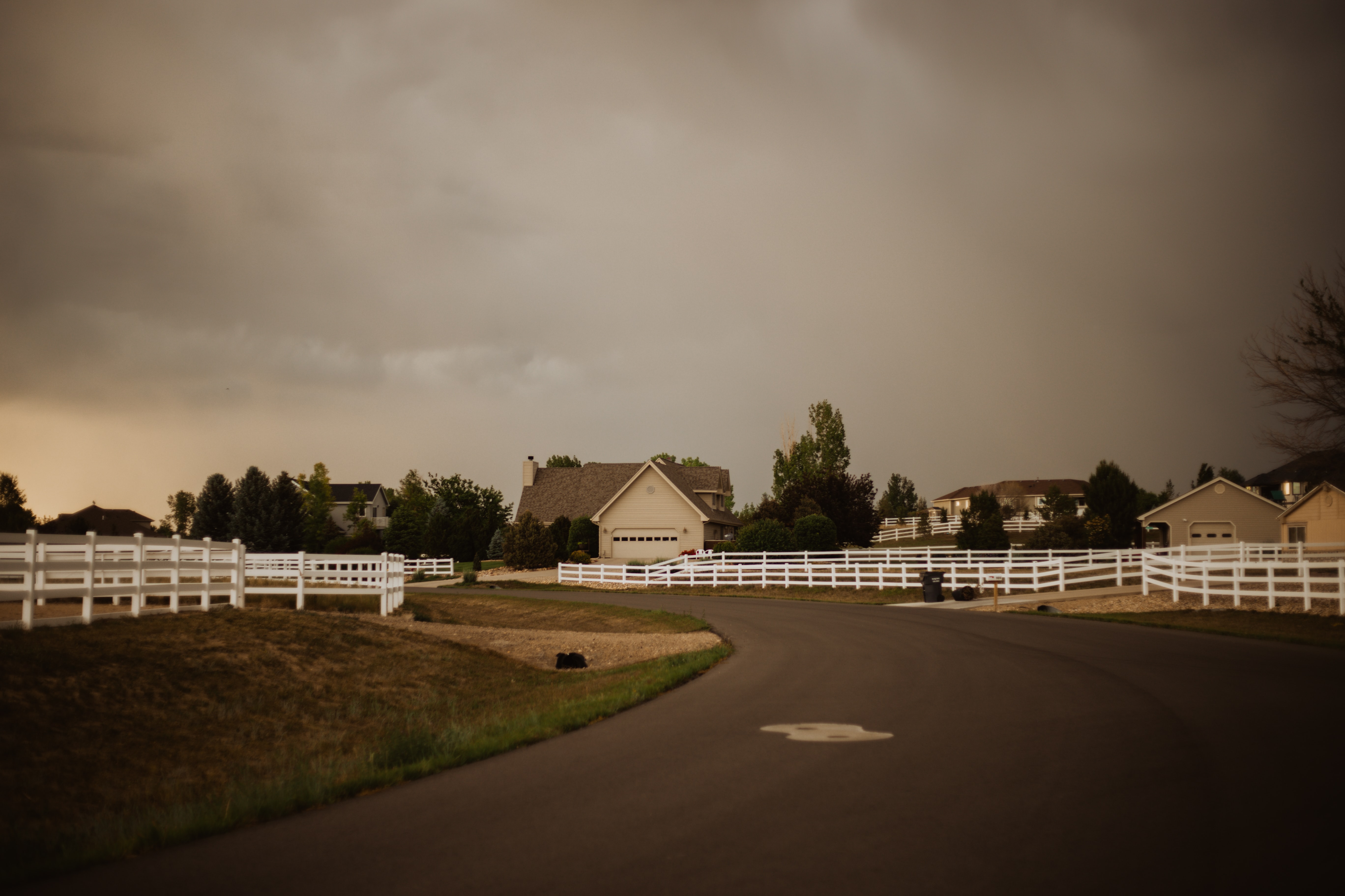white home with storm approaching in the background